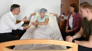Menschen, die todkrank sind, wird der Sterbesegen erteilt. Unser Bild zeigt die Heilige Kommunion, die durch einen Priester am Bett in einem Hospiz gespendet wird. Die Angehörigen können daran teilnehmen.