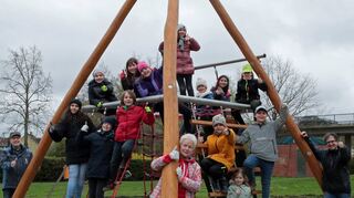 Stolz auf neue Attraktion auf dem Kinderspielplatz: Über das multifunktionale Klettertipi freuen sich hier im April 2023 Dagmara (oben v. l.), Annika, Laura, Eslem, Ceylin, Sulin und Lisa sowie Karl Götzmann (unten v. l.), Loana, Phelina, Nils, Martha Keller, Robin, Polly, Kerim und Christian Engel (Stadtverwaltung).