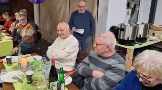 Gemeinderat und Bürgermeister-Stellvertreter Gerhard Waldecker (stehend) bei seinem Rück- und Ausblick auf die Aktivitäten der Plankstadter Liste. Die Besucher genießen derweil das schöne Ambiente auf dem Hallwachs-Hof.