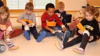 Beim Erste-Hilfe-Kurs für die Vorschulkinder wird das Anlegen von Verbänden geübt. Was am eigenen Bein nicht unbedingt einfach ist, wie die Kinder schnell merken.
