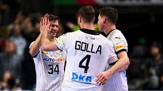 Deutschlands Handballer Rune Dahmke (l-r), Johannes Golla und Christoph Steinert jubeln bei der Handball-EM nach dem Spiel gegen Ungarn