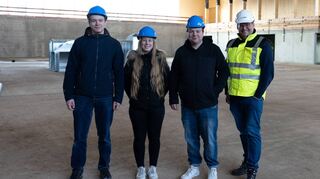 Die Mitglieder des Jugendbeirats Lars Kiefer (von links), Vanessa Stahl und Pascal Preuß sowie der Bürgermeister von Plankstadt Nils Drescher posieren für ein Foto in der neuen Sport- und Kulturhalle.