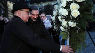Oberbürgermeister Dr. René Pöltl und Gemeindearchivar Joachim Kresin stellen einen Kranz am Denkmal auf.