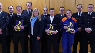 Daniel Wagner (v. l.), Nils Schumaeker, Michael Benda, Martin Schumaeker, Carsten Rupp, Simon Schumacher, Nico Seibert, Bürgermeisterin Patricia Rebmann, Julia Effenberger, Timo Kirchner, Sascha Mayer, Mia Böhm, Matthias Splett und Christoph Horsch bei der Mitgliederbeförderung der Feuerwehr Eppelheim.