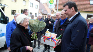 Fahrgast Brigitte Essert (80) freut sich über die Überraschung. Auch Bürgermeister Nils Drescher gratuliert. Den Bürgerbus nutze sie gerne.