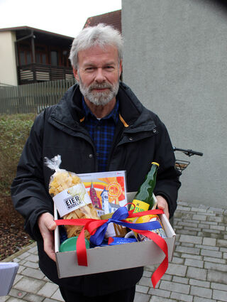 Bernhard Müüller von der Stabsstelle Umwelt hält für den Jubiläums-Fahrgast vor dem Termin Geschenke von der Gemeinde bereit. Natürlich ist er auch dabei, denn wer den Bürgerbus nutzt anstatt ins eigene Auto zu steigen, schont auch die Umwelt.
