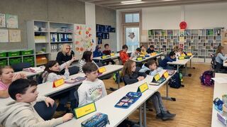 Noah Eschwey (rechts) von der Schwetzinger Zeitung/Hockenheimer Tageszeitung spricht an der Hockenheimer Hartmann-Bau-mann-Schule mit den Kindern über ihre Rechte. Die Schüler arbeiten interessiert mit.
