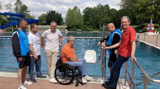 Ein Positivbeispiel der Barrierefreiheit: Behindertenbeauftragter Rudi Bamberger (Mitte) und Bäderchef Patrick Berndt (2. v. r.) fachsimpeln zu Beginn der Freibadsaison im vergangenen Jahr im Beisein (v. l.) von Schwimmmeister Marc Herbel und den Rat-hausmitarbeitern Kai Rill und Dirk Faulhaber sowie Bürgermeister Dr. Ralf Göck über den neuen Poollift.
