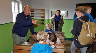 Huko-Vorsitzender Dieter Burkard (l.) erklärt den Kindern beim Museumstrag 2023 das Schulzimmer. Auch für dieses Jahr ist wieder Besonderes geplant. Archivbild: Widdrat