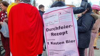 Mit einfallsreichen Kostümen ausgestattet warten die Zuschauer auf den Beginn des Umzugs.