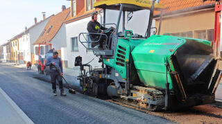 Eine gleichmäßige Einbaugeschwindigkeit und gleichbleibende Mischgutmenge sind wesentliche Faktoren für die Qualität des Straßenbelags, wie bei den Arbeiten in der Ziegelstraße zu sehen war.