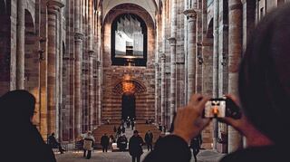 Frühlingsanfang im Dom: Die Sonne sendet ihr Licht durch das Ostfenster hinüber auf das Portal im Westen.