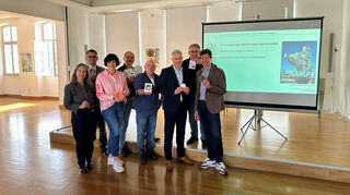 Dr. Barbara Gilsdorf (v.l.), Oliver Engert (SMS), Utz, Barnhard Motzenbäcker (Firma Knapp), Rudi Müller (Futterer), Matthias Steffan, Jürgen Gruler (SZ) und Markus Bürger präsentieren das Glücksschein zum Anbeißen.