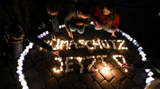 Auf diesem Symbolbild entzünden Jugendlichen Kerzen für den Klimaschutz. Zur "Earth Hour" werden eine Stunde lang alle Lampen gelöscht als Symbol für den Klimaschutz.
