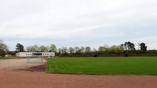 Blick auf die Rundlaufbahn und das Rasengelände vom Sportgelände des SC Olympia.