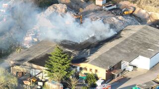 Diese Aufnahme eines Hobby-Drohnenpiloten zeigt, wie der Bagger einer auf dem Gelände ansässigen Recyclingfirma die Feuer-wehr bei den Löscharbeiten unterstützt. Ein Übergreifen des Feuers auf andere Gebäude wurde verhindert.