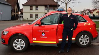 Fährt bei Einsätzen häufig voraus: Der hauptamtliche Kommandant Daniel Ernst vor dem Kommandowagen der Freiwilligen Feuerwehr Hockenheim. Die Aufgaben kennt er schon seit der Jugendfeuerwehr – und von seinem Vater.
