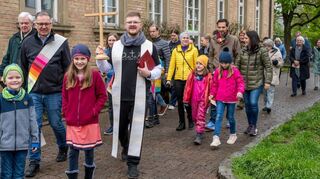 Die ökumenische Gemeinde zieht beim ökumenischen Gottesdienst in Richtung katholischen Kirche – allen voran Pfarrer Tobias Habicht (vorne rechts) in Begleitung von seinen Kindern Jakob (links)und Paula.