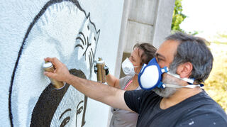 Das Künstler-Duo "Sourati" sprüht ein Wandbild auf eine Hauswand in Mannheim. In einer Führung können Interessierte Einblicke in die Mannheimer Straßenkunst gewinnen. Bild: Uwe Anspach/dpa