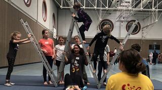 Katja Fleures (r.) bringt den Kindern ein Leiterkunstwerk bei.