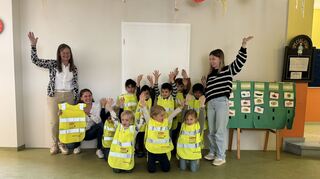 Die Freude ist groß: Beate Becker und Susanna Becker, Geschäftsführerinnen der Heless GmbH, überreichen den Kindern des Schwetzinger Spatzennests mit Erzieherin Natascha Kaiser leuchtende Warnwesten.