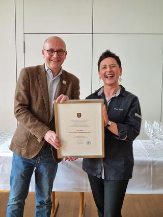Oberbürgermeister Dr. René Pöltl überreicht Hedi Rink eine Erinnerung an den Spargelanstich in Schwetzingen.
