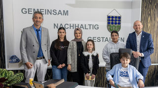 Der zehnjährige Mesut darf auf dem Bürgermeistersessel sitzen. Lehrer Mustafa Bahar (v. l.), Merve (11), Lehrerin Rabia Rusen, Sura (8) und Emine (13) freuen sich über den Besuch bei Pascal Seidel in dessen Büro im Rathaus.