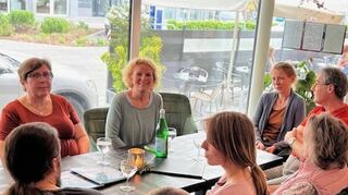 Stellt die Naturfläche für den Biolandbau über ein Gewerbegebiet: Bürgermeister-kandidatin Ingeborg Bamberg im Gespräch mit Bürgern im Eiscafé.