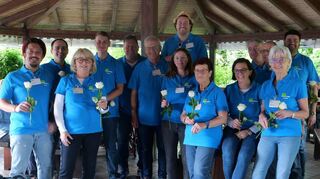 Die Freien Wähler Brühl verteilen bei ihrem Fest an der Grillhütte weiße Rosen an die Damen und sprechen über kommunalpolitische Themen.
