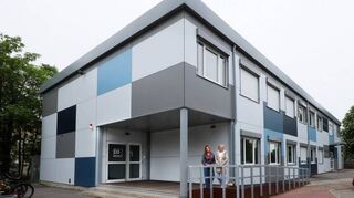 Freuen sich über die neue Barrierefreiheit in der Arndtstraße: VHS-Geschäftsstellenleiterin Katja Adrian (r.) und Kathrin Gomolla von der Mannheimer Abendakademie stehen an der Rampe vor dem Eingang zum künftigen Gebäude von VHS und Musikschule.