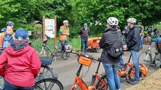 Die Radtour beim Naturerlebnistag macht auch beim Insektenhotel Station und die Teilnehmer lauschen gespannt den Ausführungen der Umweltexpterten.