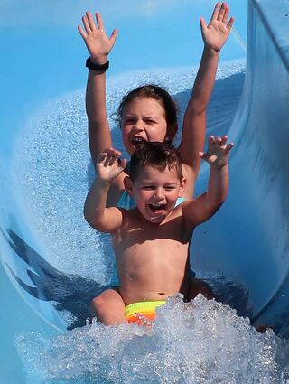 Zoe (7) und Finn (4) haben sichtlich viel Spaß auf der Wasserrutsche.