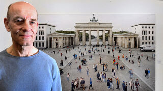 Der Fotograf Rainer Zerback vor einem seiner Bilder aus der Serie „Places of Interest“. Es zeigt den bevölkerten Pariser Platz in Berlin.