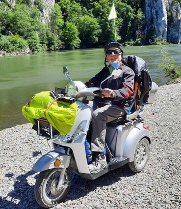 Claus Polzer auf seinem treuen Gefährten – das elektrische Dreirad in der Nähe vom Kloster Weltenburg.