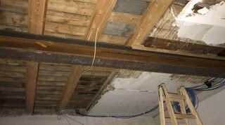 Die hohe Brandlast der Rohdecken-Holzkonstruktion mit ungeschütztem Stahlträger verdeutlicht die Notwendigkeit einer Brandmeldeanlage.