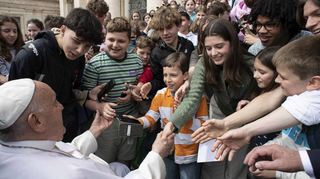 Die Chorknaben und die jungen Sängerinnen aus Speyer machen Selfies mit Papst Franziskus.