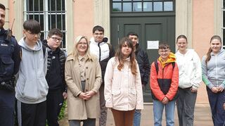Auf dem Foto vor dem Gericht ist außerden Jugendlichen Präventionspolizist Tobias Hoffmann (l.) und Schulsozialarbeiterin Anna Schlitt (4. v. l.) zu sehen.