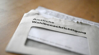 Eine geöffnete amtliche Wahlbenachrichtigung liegt auf einem Tisch.