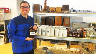 Lars Maurer vor einem Regal mit Exponaten aus der ehemaligen Hof-Apotheke.