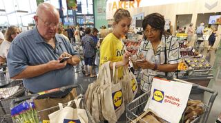 Rabatt-Apps sind bei Kunden sehr beliebt. Hier erklärt eine Lidl-Mitarbeiterin in den USA die Funktionsweise der App.