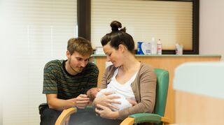 Die Bindung zwischen Eltern und Baby von Anfang an fördern.