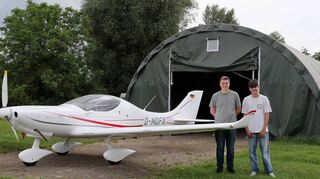 Zeichen des Neuanfangs beim Sportfliegerclub Hockenheim: Jugendwart Johannes Schweigler (l.) und Fabio Hillenbrand stehen mit dem neuen Ultraleichtflugzeug, einer WT 9 Dynamic, vor der Zelthalle, die der Verein als Übergangslösung bis zum Wiederaufbau des abgebrannten Hangars angeschafft hat.