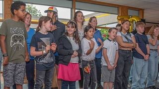 Der Schülerchor der sechsten Klasse eröffnet das Jubiläumsfest zusammen mit der Lehrerband.