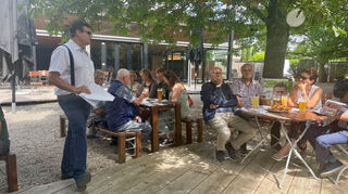 Nils Drescher(links) stellt am Sonntagmorgen sein Wahlprogramm beim Frühschoppen im Weldegarten in Plankstadt vor.