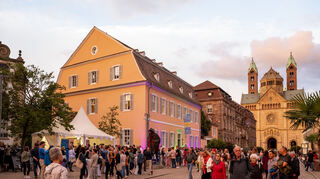 Die 23. Speyerer Kulturnacht, Kult(o)urnacht zieht bei etwas seltsamem Wetter zahlreiche Besucher zu den rund 25 Kultureinrichtungen wie Museen und Galerien, die ein buntes Programm rund um Kunst und Kultur bieten. Die obere Maximilianstrasse am Geschirrplätzel ist zu jeder Zeit ein beliebter Treffpunkt und der Dom gerade im Abendlicht der untergehenden Sonne schön beleuchtet.