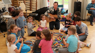 Philipp Wolfart (hinten) begleitet die Kleinen mit der Gitarre.