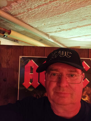 Dieter Müller vor dem AC/DC-Plakat in seinem Keller.