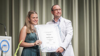Xenia Heer bekommt vom Vorsitzenden des Elternbeirats den Gauß-Preis überreicht.