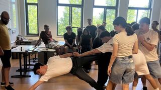 Schüler vom TG 12 üben, wie man sich aufeinander verlassen können muss beim Workshop der Caritas zu den Freiwilligendiensten.