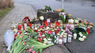 Blumen und Kerzen liegen zum Gedenken an das Opfer liegen vor der Schule. dpa